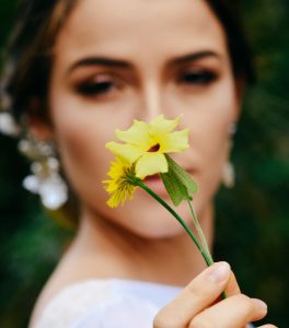 Γυναίκα με σκουλαρίκια κρατάει λουλούδι